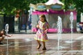 Two sisters playing with fountain splash