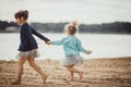 Two sisters playing on the shore of the lake