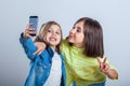 Two sisters posing and taking selfies in the studio Royalty Free Stock Photo