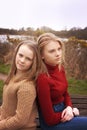 Two sisters sitting back to back Royalty Free Stock Photo