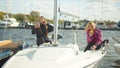 Two sisters sitting on board a white sports yacht take selfies on smartphones and relax after a sailing race. Royalty Free Stock Photo