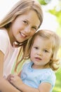 Two sisters sitting outdoors smiling Royalty Free Stock Photo