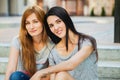 Two sisters sitting on the stairs and listening music Royalty Free Stock Photo