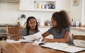 Two Sisters Sitting At Table In Kitchen Doing Homework Royalty Free Stock Photo