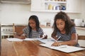 Two Sisters Sitting At Table In Kitchen Doing Homework Royalty Free Stock Photo