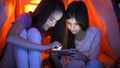 Portrait of two sisters with smartphone in bedroom at night Royalty Free Stock Photo