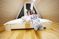 Two sisters in soft warm pajamas playing at wooden cabin home. Concept of childhood, leisure activity, happiness. Little girls