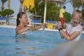 Two sisters splashing around in the pool and laughing