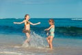 Two sisters splashing on the beach