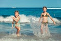 Two sisters splashing on the beach Royalty Free Stock Photo