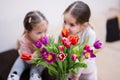 Two sisters with spring tulip bouquet. Holiday decor with flowers colorful tulips Royalty Free Stock Photo