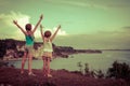 Two sisters standing on the beach and pulled up his hands Royalty Free Stock Photo
