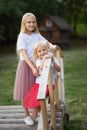 Two sisters are standing on wooden bridge in the park Royalty Free Stock Photo