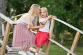 Two sisters are standing on wooden bridge in the park Royalty Free Stock Photo