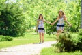 Two sisters together walk in a beautiful city park