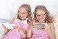 Portrait of two sisters twins using smartphones