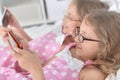 Portrait of two sisters twins using smartphones