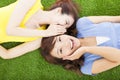 Two sisters whispering gossip on the grass Royalty Free Stock Photo