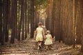 Two sisters in yellow dresses go through the forest holding hand Royalty Free Stock Photo