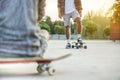 Two skateboarders training in skate park at sunset - Close up of young tattoo man training with longboard in city urban contest -