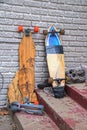 Two skateboards - one repaired with duct tape - propped against a wall on dirty grungy concrete steps with old tennis shoes thrown Royalty Free Stock Photo