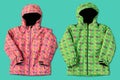 Two ski jackets, green and pink, on a turquoise background Royalty Free Stock Photo