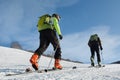 Two ski-mountaineers climb the mountain on skis