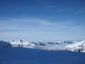 Two skiers in front of a cliff on a mountainside over the clouds in the French Alps.