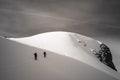 Two skiers hiking on a snowy mountain under a dark cloudy sky Royalty Free Stock Photo