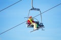 Two skiers lifting on chairlift against blue sky Royalty Free Stock Photo