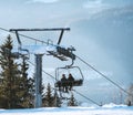 Two skiers riding a cable chair lift at a ski resort on a sunny day