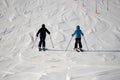 two skiers sidebyside on a wide, open piste Royalty Free Stock Photo