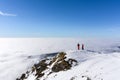 Two skiers on top of mountain above the clouds Royalty Free Stock Photo