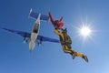 Two skydivers in color suits have just jumped out of an airplane.