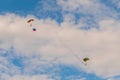 Two skydivers flying with parachute against blue sky - extreme sport concept