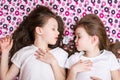 Two sleeping girls and a white alarm clock in between