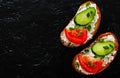 Slice of bread with cream cheese, cucumber, tomato on a black stone board. with copy space. top view Royalty Free Stock Photo