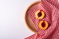 Two slice of peach nectarine fruit with seed in wooden plate with red checkered tablecloth on white background Royalty Free Stock Photo