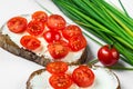 Two sliced bread, butter, cherry tomato, chive. On white background, closeup. Royalty Free Stock Photo