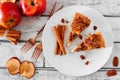 Two slices of autumn caramel apple pecan cheesecake, top view table scene over white wood