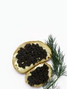 Two slices of baguette with butter and black caviar isolated on white background. Luxurious delicacy appetizer Royalty Free Stock Photo