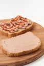 Two slices of bread coated with pate and ketchup on wooden board Royalty Free Stock Photo