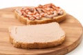 Two slices of bread coated with pate and ketchup on wooden board Royalty Free Stock Photo