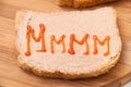 Two slices of bread coated with pate and ketchup on wooden board Royalty Free Stock Photo