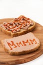 Two slices of bread coated with pate and ketchup on wooden board Royalty Free Stock Photo