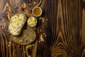 Two slices of bread and a cup of honey and butter, peanuts and decorated with pieces of dried apple lying on a wooden backgroundt Royalty Free Stock Photo