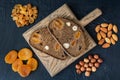 Two slices of bread with nuts and dried fruit on a wooden cutting board, a healthy snack. Royalty Free Stock Photo