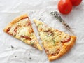 Two slices of freshly made pepperoni pizza upon baking parchment. Food background. Royalty Free Stock Photo