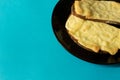 Two slices of grilled cheese on toast on black plate and bright Royalty Free Stock Photo