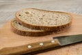 Two slices of rye bread and a knife on a wooden board. Close-up. Royalty Free Stock Photo